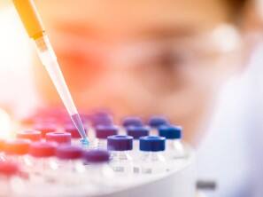 A lab technician using a pipette in a laboratory